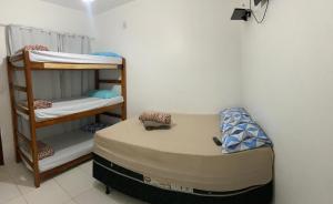 a small room with a bunk bed and a shelf at Oceano Suítes in Arraial do Cabo