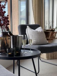 zwei Gläser Wein auf einem Tisch neben einem Stuhl in der Unterkunft BrimiBue Hotel in Lom