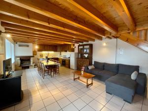 uma sala de estar com um sofá, uma mesa e uma cozinha em Gîte Saint-Pierre-du-Champ, 5 pièces, 8 personnes - FR-1-582-61 em Saint-Pierre-Duchamp