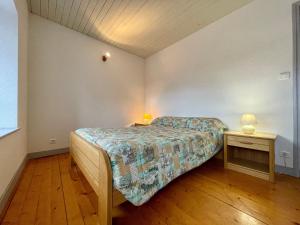 een slaapkamer met een bed en twee lampen op tafels bij Gîte Saint-Pierre-du-Champ, 5 pièces, 8 personnes - FR-1-582-61 in Saint-Pierre-Duchamp
