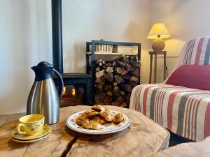 einen Tisch mit einem Teller Gebäck und einer Tasse Kaffee in der Unterkunft Gîte 10 pers avec 4 chambres et 3 salles d'eau, animaux admis - FR-1-582-94 in La Besseyre-Saint-Mary + 22 Fotos
