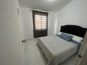 1 dormitorio con cama y ventana en Casa Conjunto Rosario Norte 2 en Valledupar