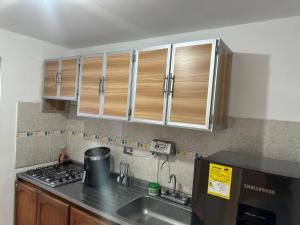 a kitchen with wooden cabinets and a sink at Casa Conjunto Rosario Norte 2 in Valledupar