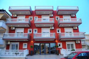 a red building with white balconies on it at Villa-Andromeda in Paralia Katerinis