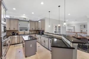 a large kitchen with white cabinets and a large island at Cozy and Roomy Home with Private Pool in Houston