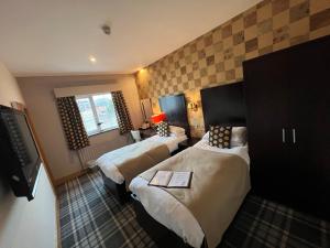 a hotel room with two beds and a window at Inn On The Prom At The Fernlea Hotel in Lytham St Annes