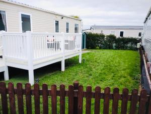 a backyard with a white fence and a house at 32 Holiday Resort Unity in Brean