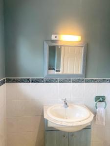 a bathroom with a sink and a mirror at The wellbeing XCAPE Country Barn PT & Masseur - H in Nuneaton