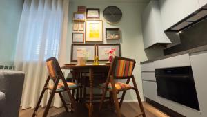 a dining room table with two chairs and a clock at Novo Taccheo by Ca-Sa Check in Chioggia