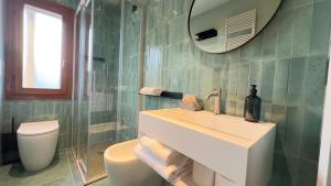 a bathroom with a sink and a toilet and a mirror at Novo Taccheo by Ca-Sa Check in Chioggia +29 photos