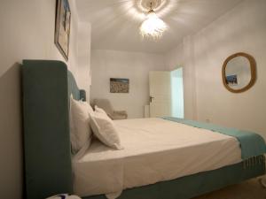 - une chambre avec un grand lit et une tête de lit verte dans l'établissement au cœur de sidi bou said, à Sidi Bou Saïd