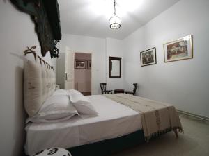 au cœur de sidi bou said في سيدي بو سعيد: غرفة نوم بسرير ذو شراشف ووسائد بيضاء