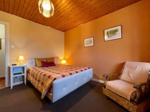 1 dormitorio con 1 cama y 1 silla en Gîte Saint-Haon, 4 pièces, 5 personnes - FR-1-582-211 en Saint-Haon