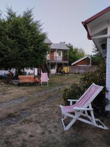 różowo-białe krzesło siedzące przed domem w obiekcie Cabañas Camahueto w mieście Licán Ray