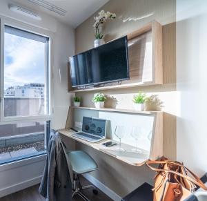 a home office with a desk with a laptop and a window at Break & Home Clermont-Ferrand Les Carmes Dechaux in Clermont-Ferrand