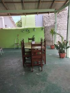 een tafel en stoelen in een kamer met een groene muur bij Casa Parintins in Parintins
