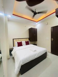 a bedroom with a bed with a ceiling fan at Hotel Pru with car parking in Alambagh