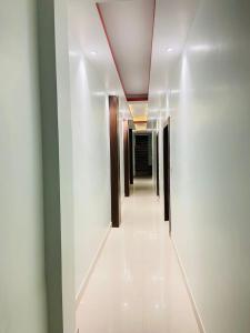 a corridor of a hallway with white walls and a purple ceiling at Hotel Pru with car parking in Alambagh