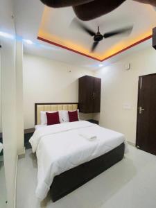 a bedroom with a bed with a ceiling fan at Hotel Pru with car parking in Alambagh