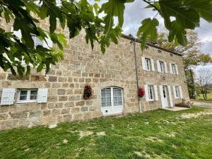 an old stone building with white doors and windows at Gîte Saint-Jeures, 5 pièces, 8 personnes - FR-1-582-254 in Saint-Jeures