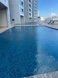 a large blue swimming pool in a building at Ocean View Luxury Suites in Ajman 