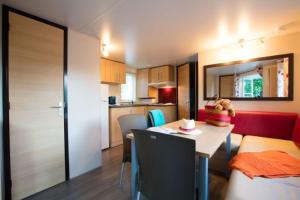 ein kleines Apartment mit einem Esstisch und einer Küche in der Unterkunft CAMPING LA CLE DE SAONE in Crêches-sur-Saône