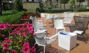grupa krzeseł i stołów oraz różowe kwiaty w obiekcie Casale dei cento Acri we Florencji