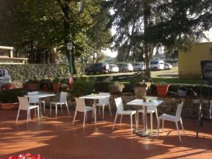 eine Gruppe von Tischen und Stühlen auf einer Terrasse in der Unterkunft Casale dei cento Acri in Florenz