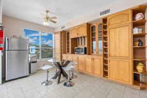 uma cozinha com armários de madeira, um frigorífico e uma mesa em Panoramic View Villa with Pool - Events OK em Ramona