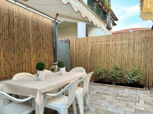 a table and chairs on a patio with a fence at Forte 27 centro in Forte dei Marmi
