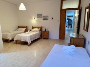 een slaapkamer met 2 bedden en een deur naar een gang bij Paradise 1 in Żebbuġ