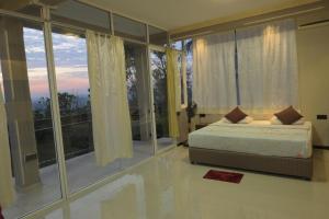 sypialnia z łóżkiem i dużym oknem w obiekcie Eye Catch Kandy w mieście Kandy