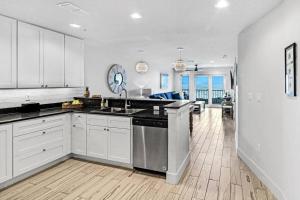 a large kitchen with white cabinets and a sink at Grand Caribbean 4007 in Port Aransas