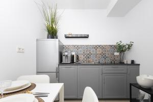 a kitchen with a refrigerator and a table and chairs at Apartament Gocławska SWPS PGE Narodowy Dworzec Wschodni Soho Factory in Warsaw