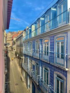 un edificio azul con balcones en una calle de la ciudad en Central Avenida Liberdade 3, en Lisboa