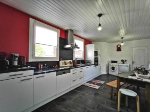 eine große Küche mit weißen Schränken und roten Wänden in der Unterkunft Gîte Saint-Vidal, 4 pièces, 6 personnes - FR-1-582-308 in Saint-Vidal