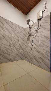 a shower in a room with a stone wall at Regno Villa the Infinity by Nflix in Panadura +106 photos