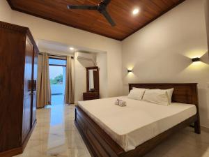 a bedroom with a bed with a ceiling fan at Regno Residence the Infinity by Netflix in Panadura
