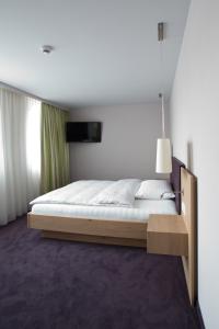 een slaapkamer met een groot bed met een houten frame bij OCHSEN LODGE by Ochsen Lenzburg in Lenzburg