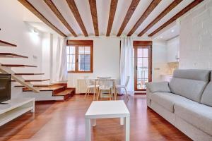 ein Wohnzimmer mit einem Sofa und einem Tisch in der Unterkunft Dúplex Portales By Clabao in Logroño