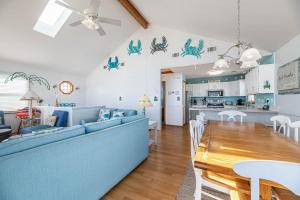 a living room and kitchen with a blue couch and a table at Key to Paradise in Kitty Hawk