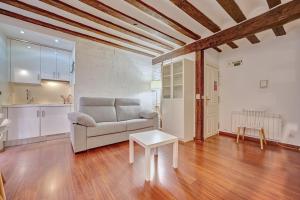 ein Wohnzimmer mit einem Sofa und einem Tisch in der Unterkunft Dúplex Portales By Clabao in Logroño