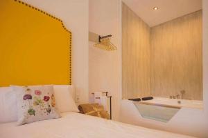 1 dormitorio con cama, ventana y bañera en LOFT TÚ y YO, en Alcalá del Júcar