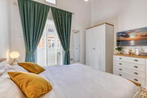 a bedroom with a large bed with green curtains at Sliema Luxury House in Sliema