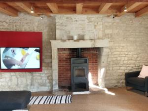 a living room with a brick fireplace with a tv at Charmante maison XVIIIème rénovée avec piscine et terrasse, proche rivière et pistes cyclables - FR-1-426-99 in Fontenay-le-Comte