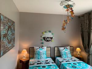 2 camas individuales en una habitación con sábanas azules en Gîte Brem, 5 pièces, 8 personnes - FR-1-426-86 en Brem-Sur-Mer