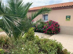 une maison avec des fleurs roses devant elle dans l'établissement Gîte Brem, 5 pièces, 8 personnes - FR-1-426-86, à Brem-sur-Mer