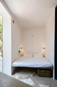 Bett in einem Zimmer mit weißen Wänden in der Unterkunft Casa Norah Puglia in Serranova