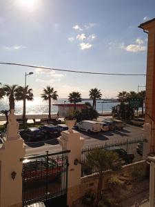 Blick auf einen Parkplatz mit Palmen und das Meer in der Unterkunft Hotel Lido in Varraze