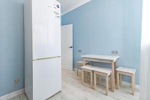 uma cozinha com uma mesa e um frigorífico em ЖК «Комсомольский» em Taldykolʼ